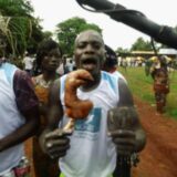 un homme exhibant une patte de chien Pya Photo Tingayama Mawo